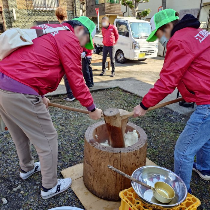 餅つき大会で杵を振り上げる町会役員